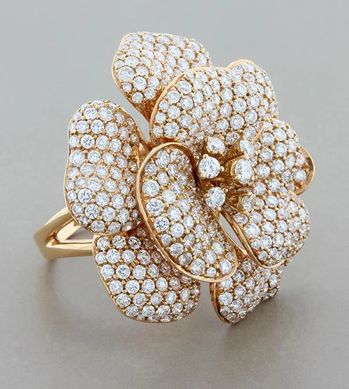 Unedited rose gold pavé flower cocktail ring on a grey background, with flat lighting and dull stones