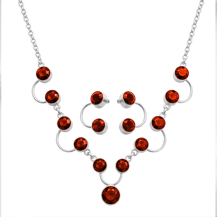 Silver-tone necklace and stud earring set with round red stones, cut out on a plain white background